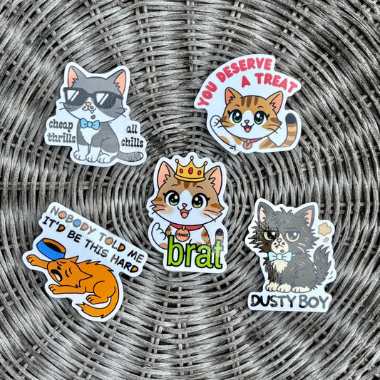 Set of cat-themed stickers on a wicker surface