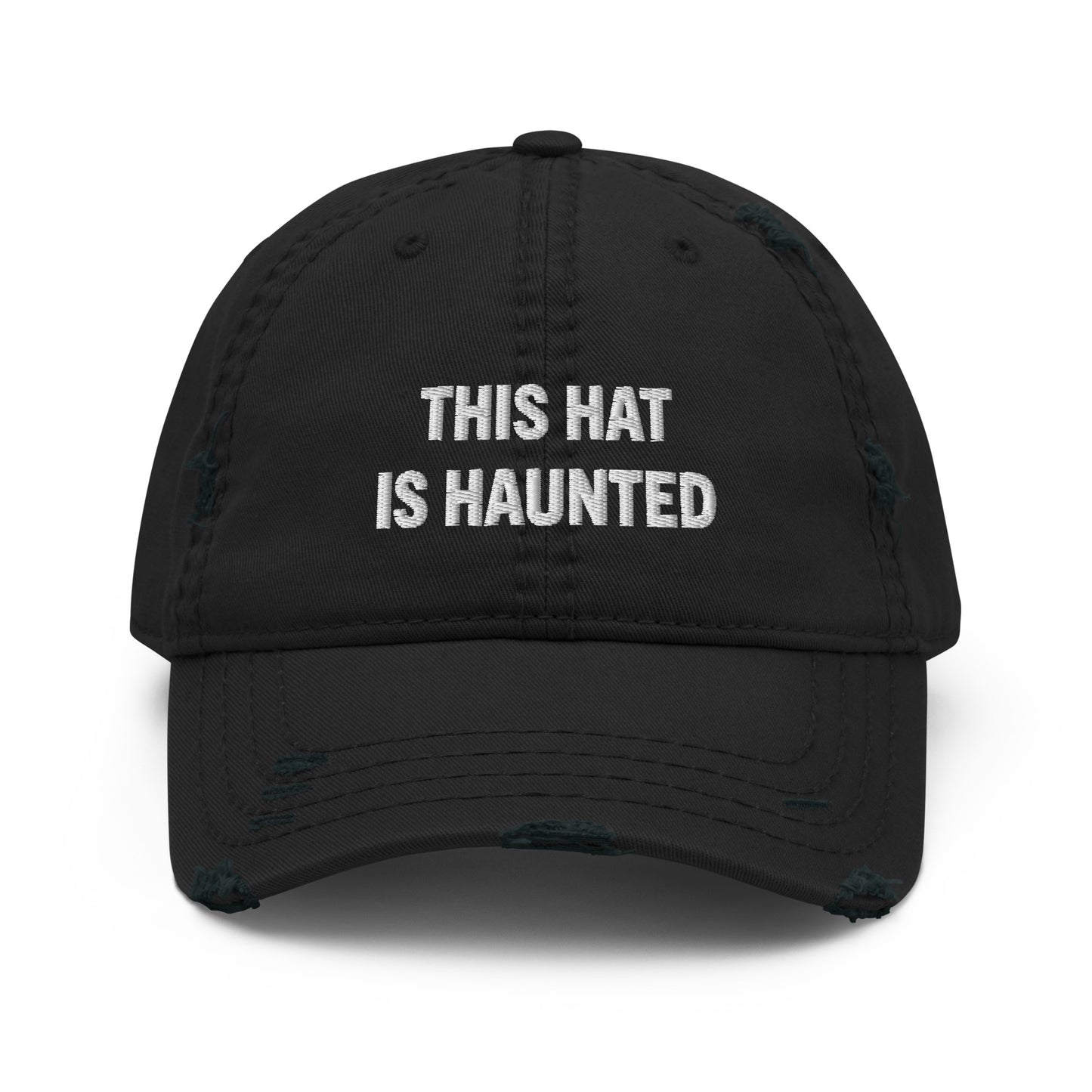 Distressed dad hat in black with white embroidered text reading “this hat is haunted.”