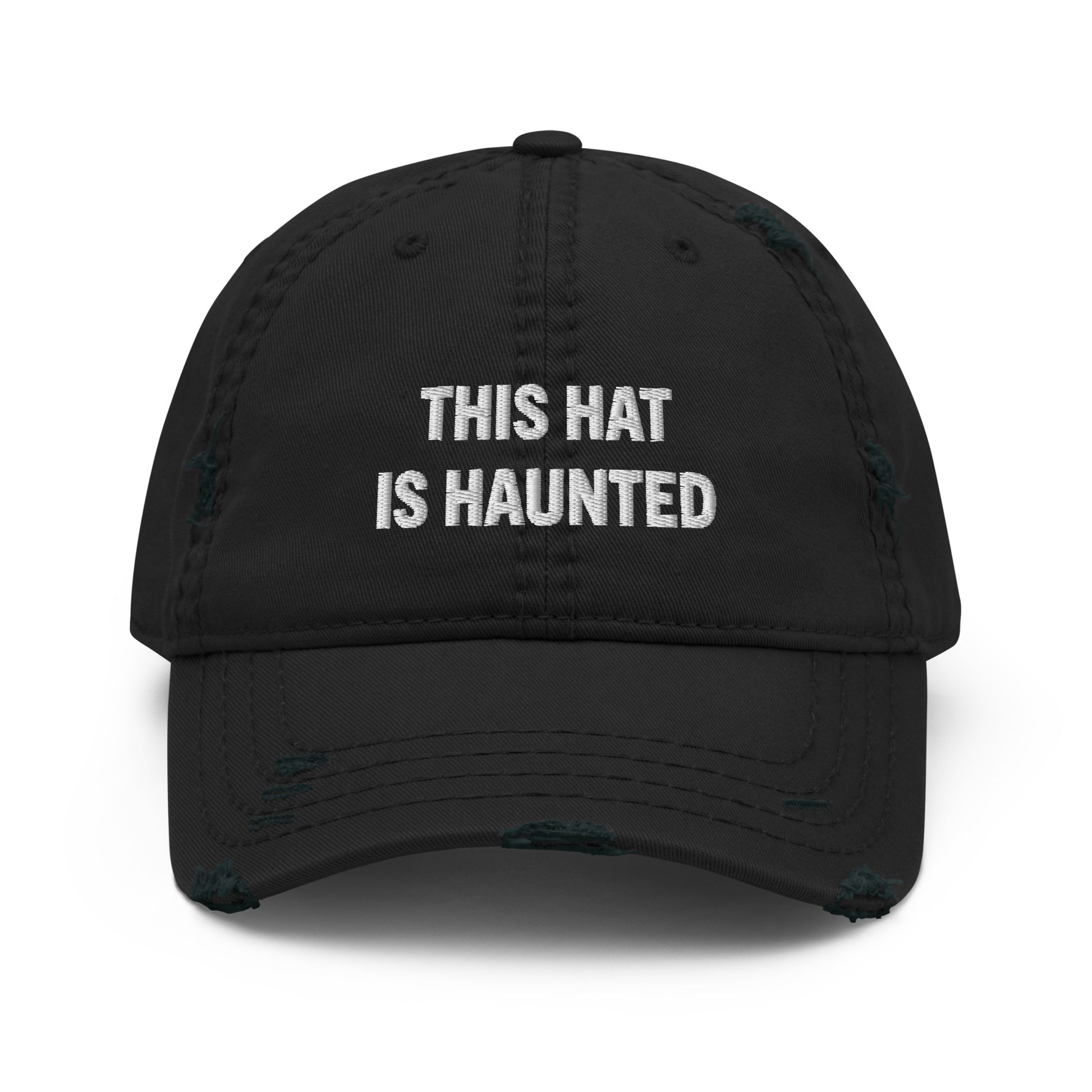 Distressed dad hat in black with white embroidered text reading “this hat is haunted.”