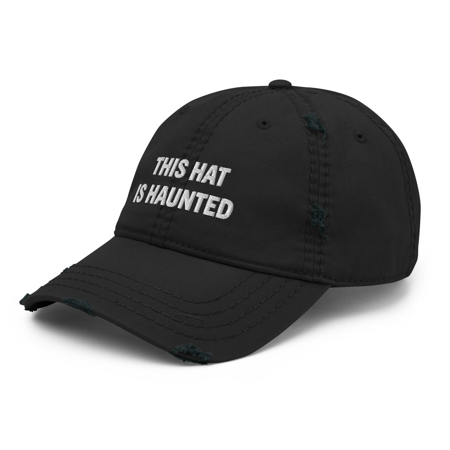 Distressed dad hat in black with white embroidered text reading “this hat is haunted.”