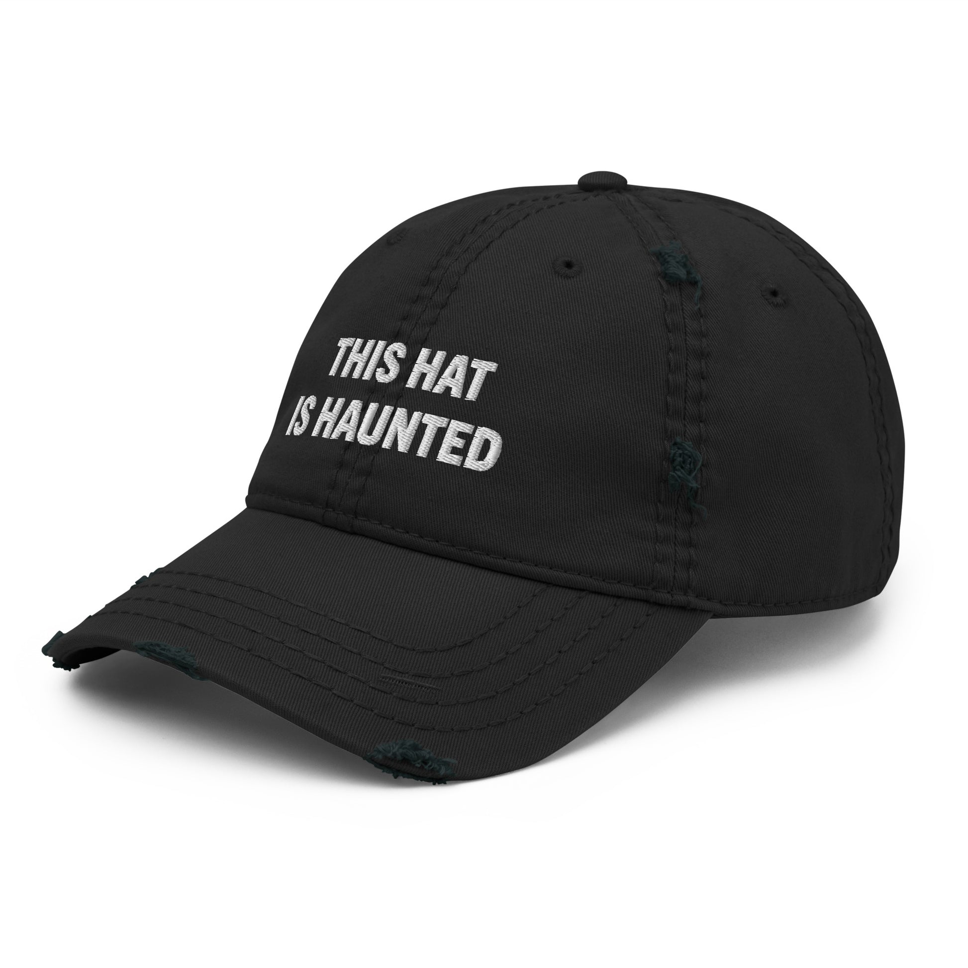 Distressed dad hat in black with white embroidered text reading “this hat is haunted.”